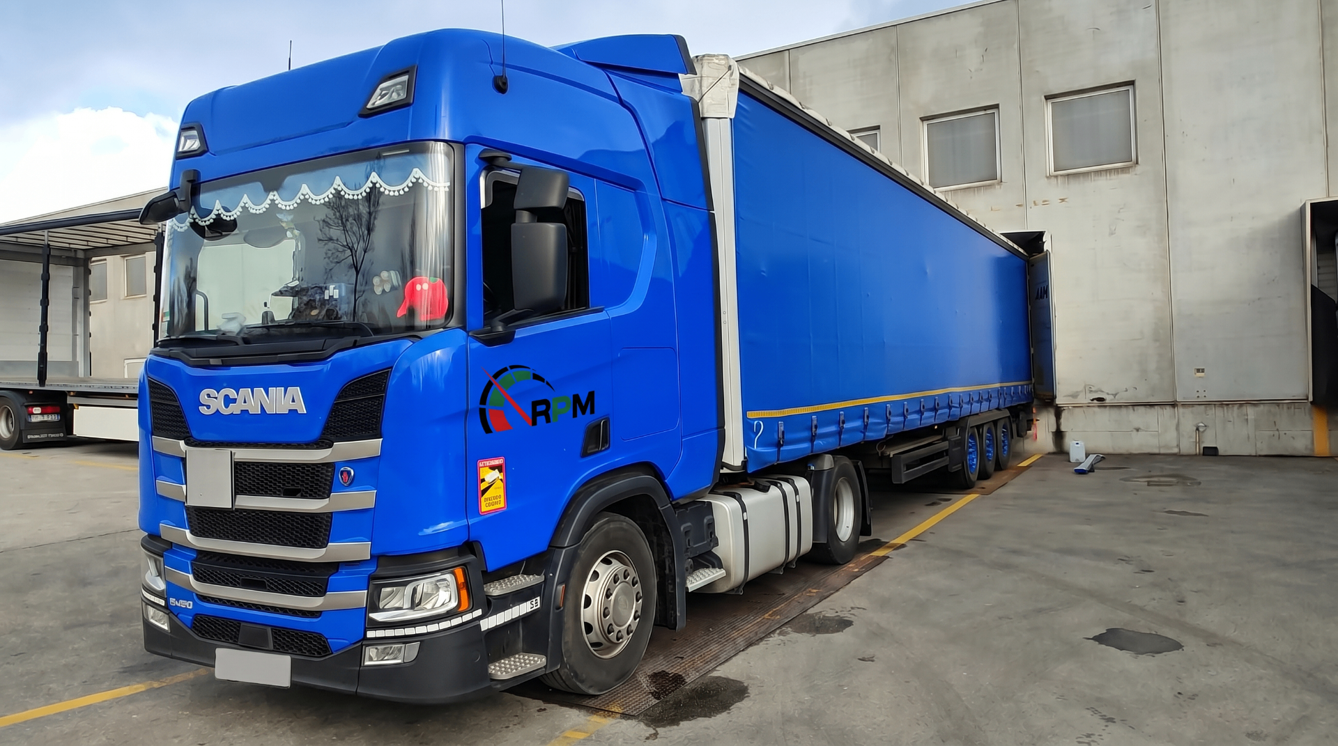 Ciągnik siodłowy Scania R450 z naczepą plandekową brandowaną logo RPM Logistics